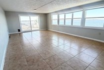 Expansive living space with tiled floors and large windows offering stunning waterfront views, perfect for a serene lifestyle.