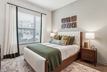 Experience serene comfort in this beautifully designed bedroom featuring chic decor and ample natural light.