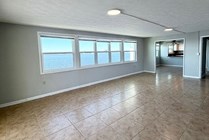 Spacious apartment with large windows offering stunning waterfront views and abundant natural light.